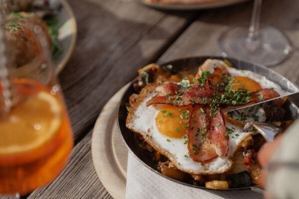 Spiegelei mit Speck in der Pfanne auf der Terrasse der Auenhütte im Kleinwalsertal mit Aperol