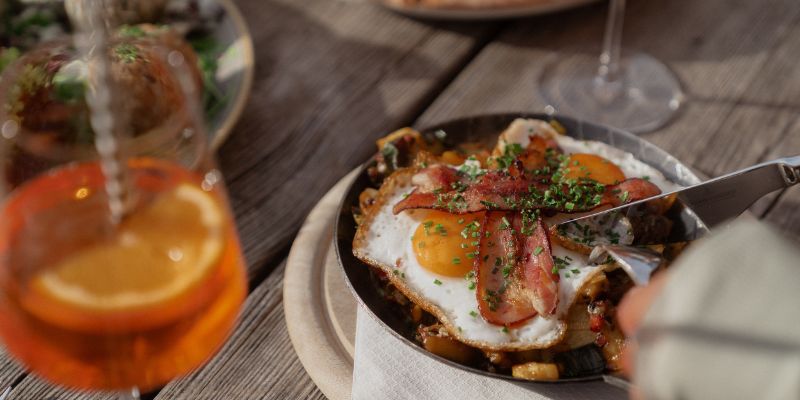 Spiegelei mit Speck in der Pfanne auf der Terrasse der Auenhütte im Kleinwalsertal mit Aperol